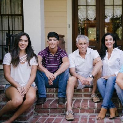 Michelle Odinet and Dr. Kenneth Odinet are wearing white shorts as Elijah and Elizabeth are sitting next to them for the picture.